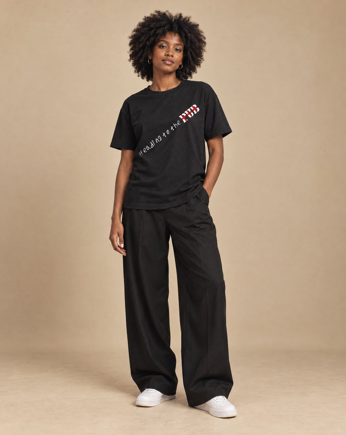 Female model wearing SHOPHOODIE HEADING TO THE PUB BRITISH ENGLAND Pure Cotton Unisex T-Shirt — 180 GSM, studio shot