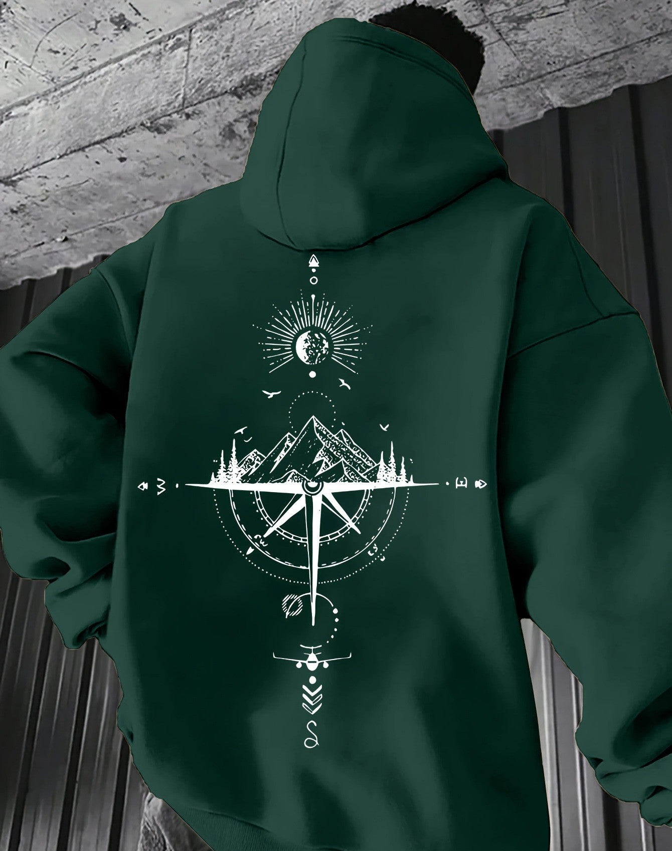 Green hoodie with a white geometric design on the back, worn by a person.