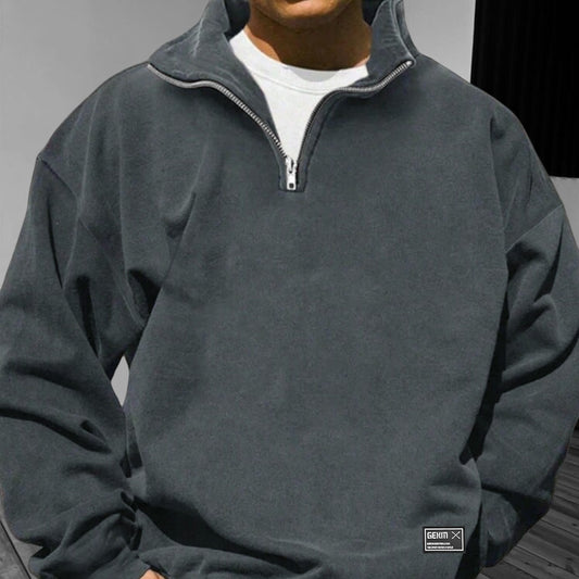 Person wearing a gray quarter-zip sweatshirt with a visible brand logo.