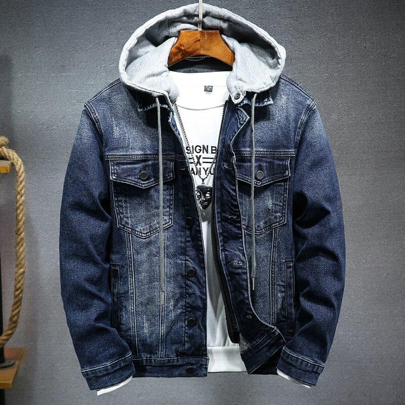 Denim jacket with gray hoodie on a hanger against a gray background
