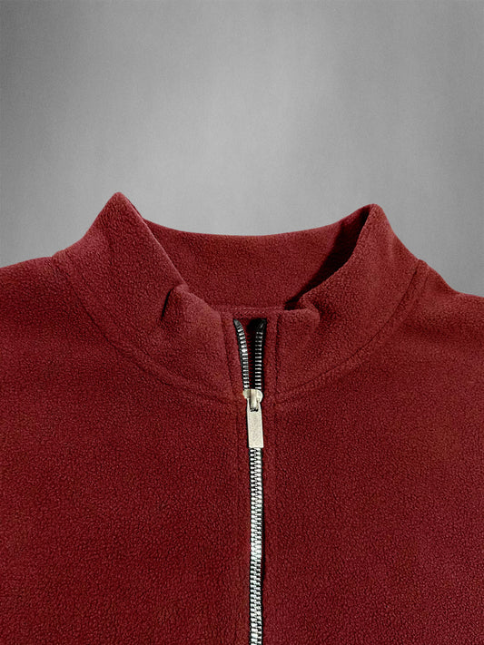 Close-up of a red fleece jacket with a zipper on a gray background