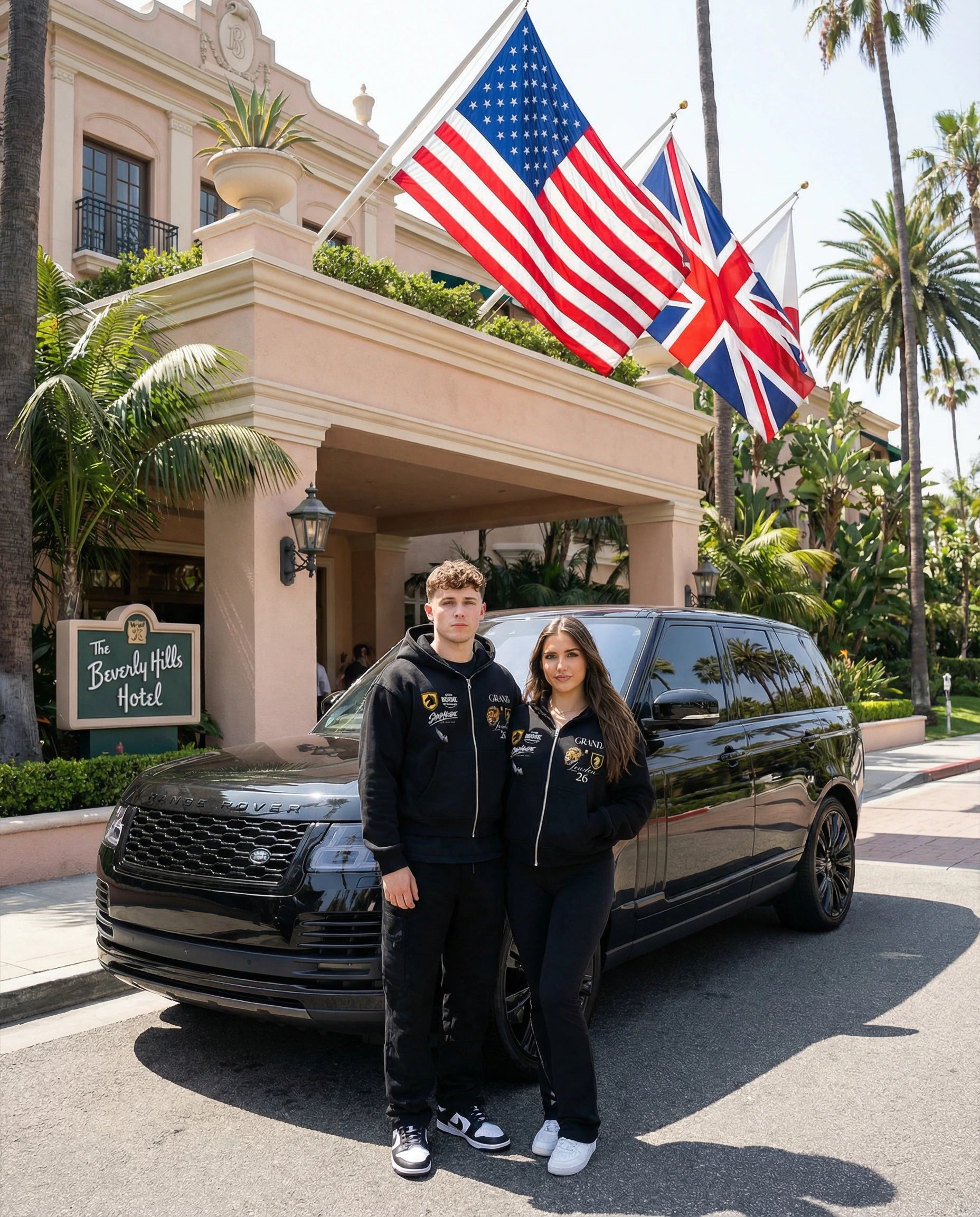 Two people standing in front of a black SUV with American and British flags in front of The Beverly Hills Hotel ShopHoodie™