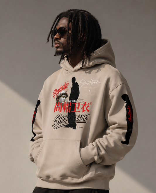 Person wearing a beige hoodie with graphic designs and text on a gray background