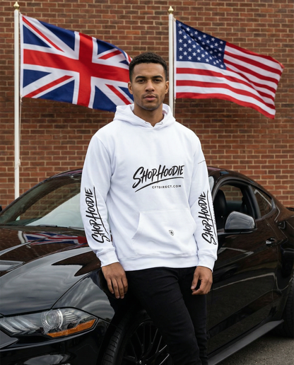 Man wearing a white hoodie with branding in front of a car and two flags.