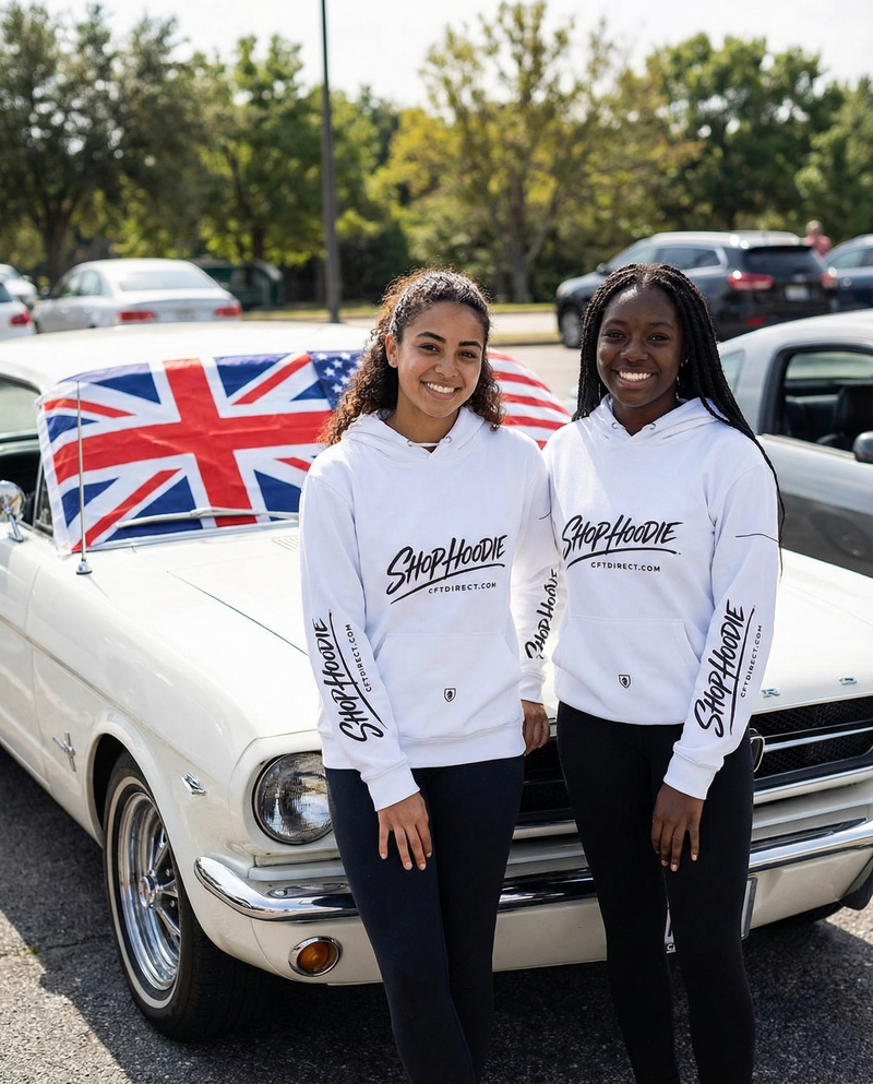 Two people wearing 'Shop Hoodie' sweatshirts standing in front of a classic car with a British flag.