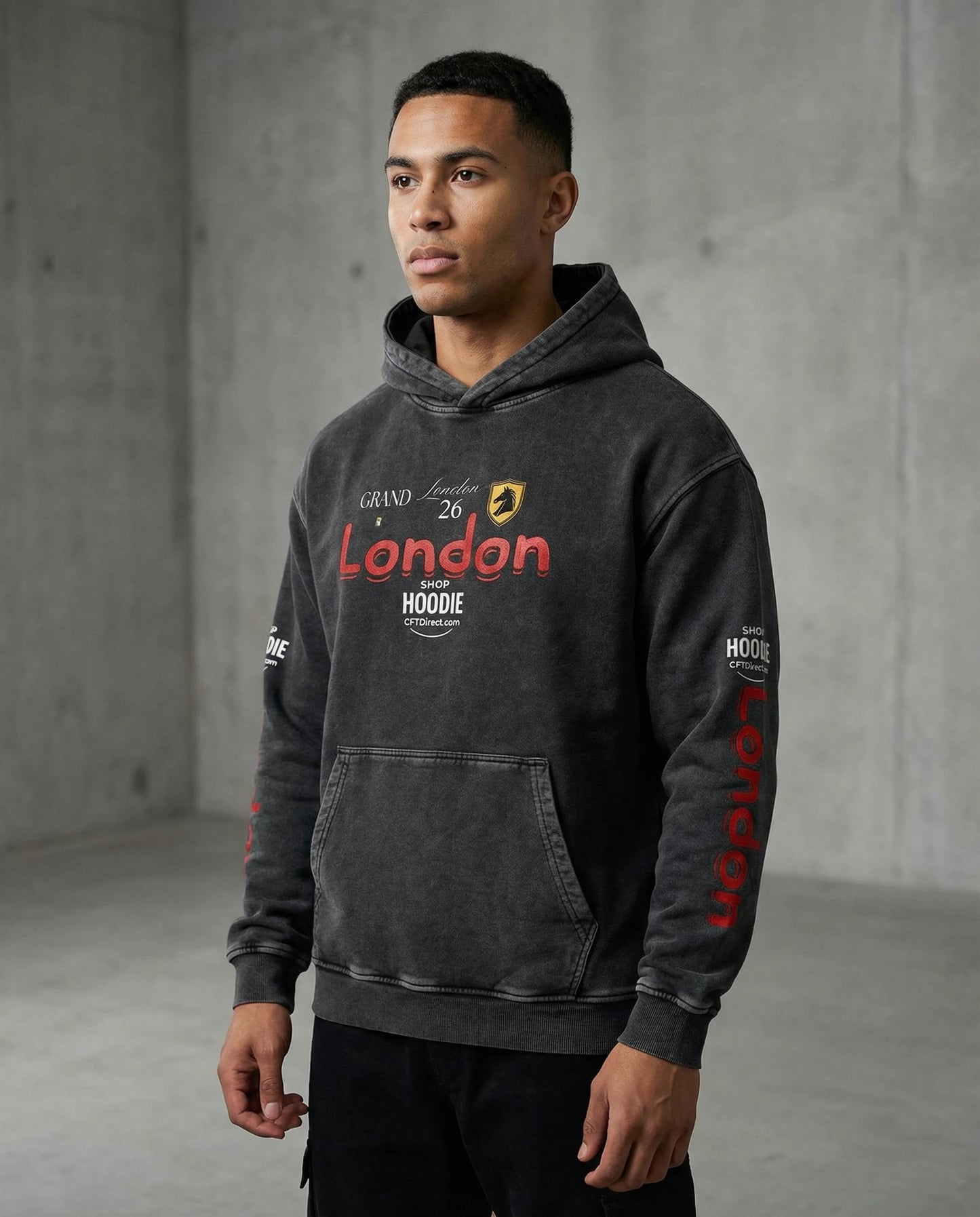 Man wearing a dark gray hoodie with red and yellow text against a concrete wall.