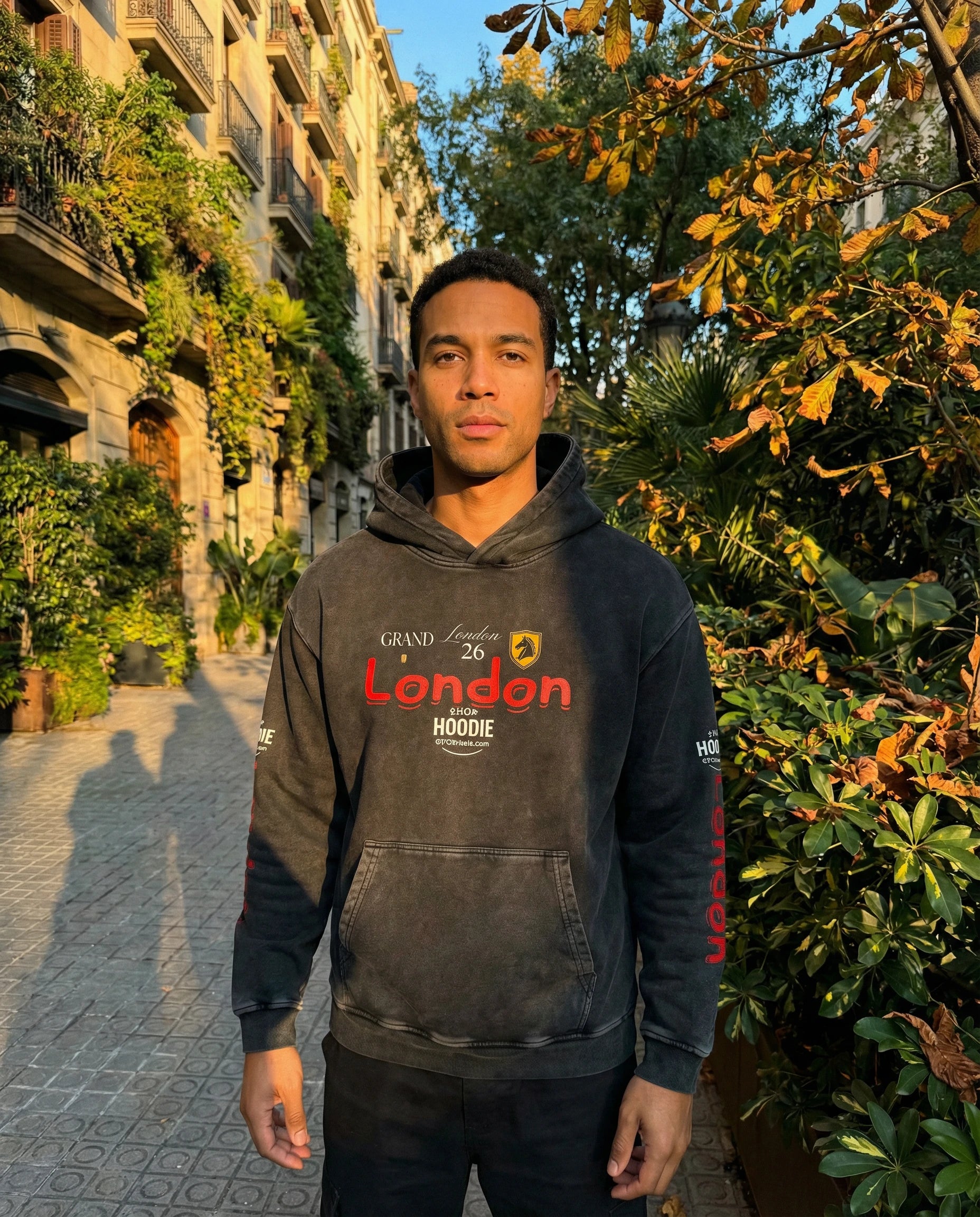 Man wearing a hoodie with 'Grand London' text standing outdoors.