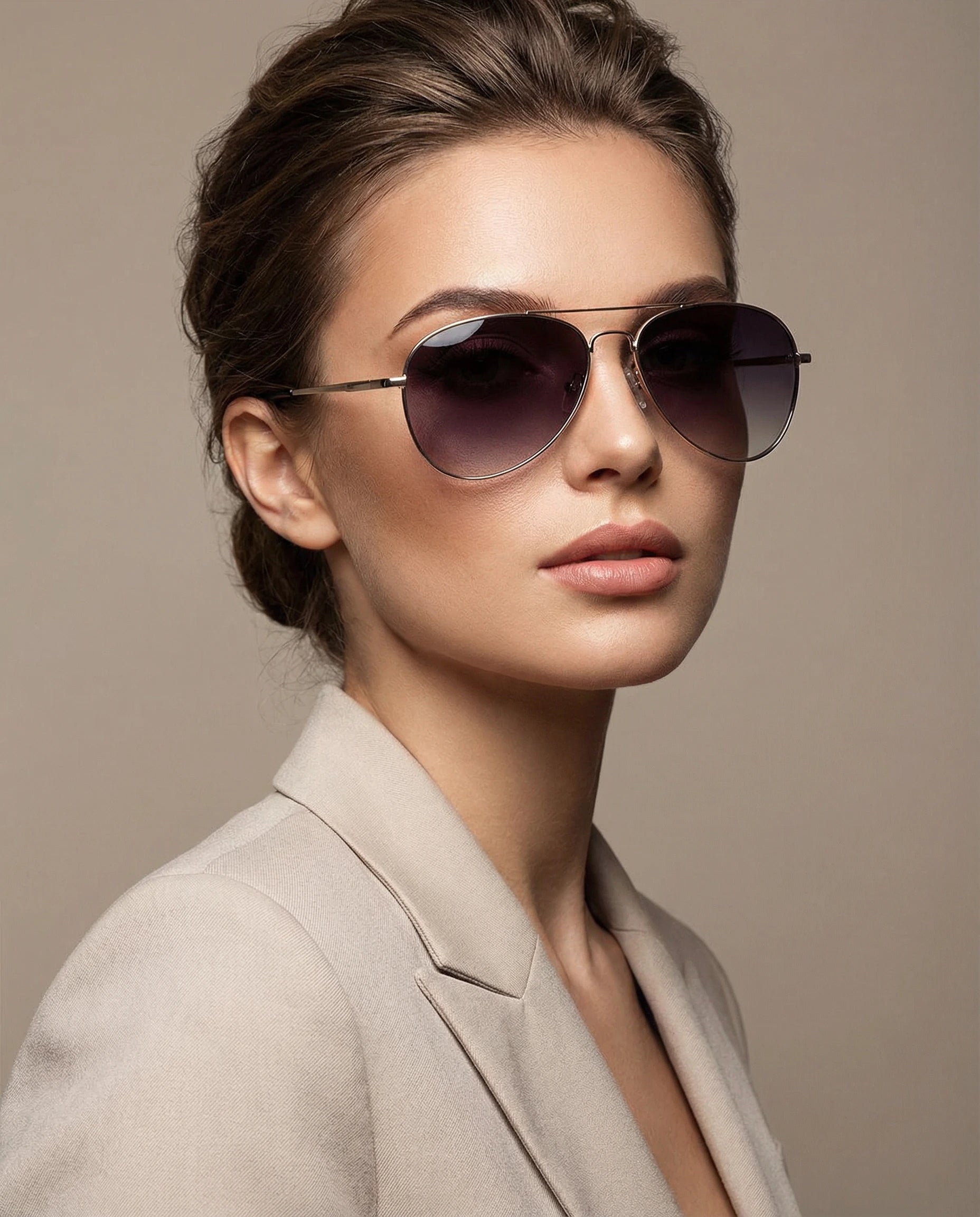 Woman wearing aviator sunglasses with a neutral background