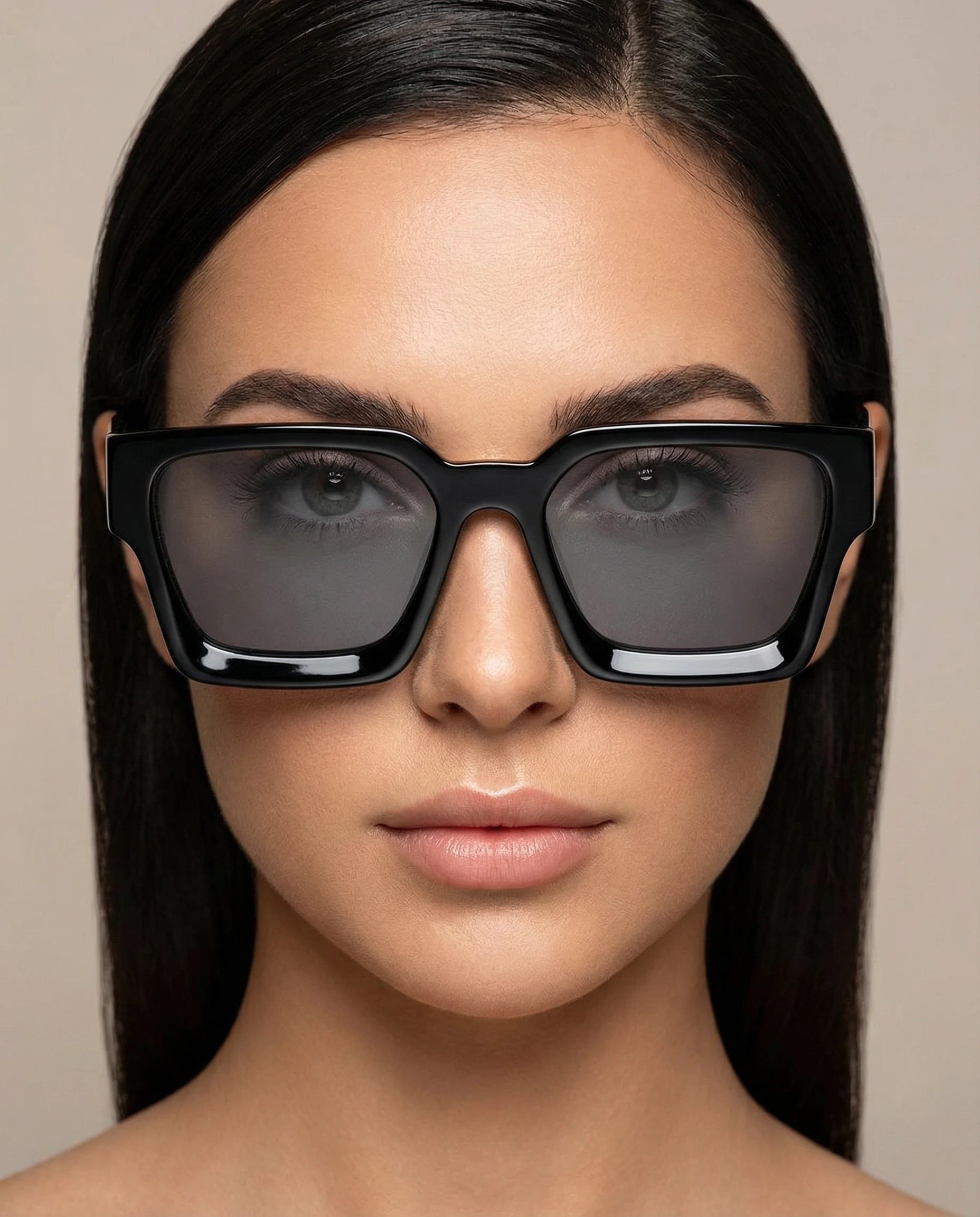 Woman wearing black sunglasses with a neutral background
