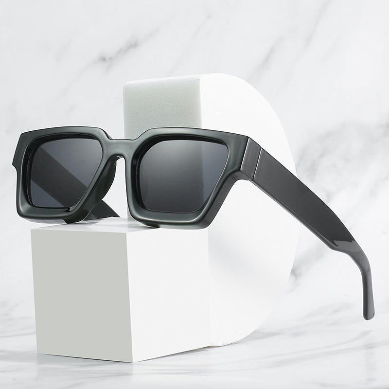 Black sunglasses on a white cube with a white background