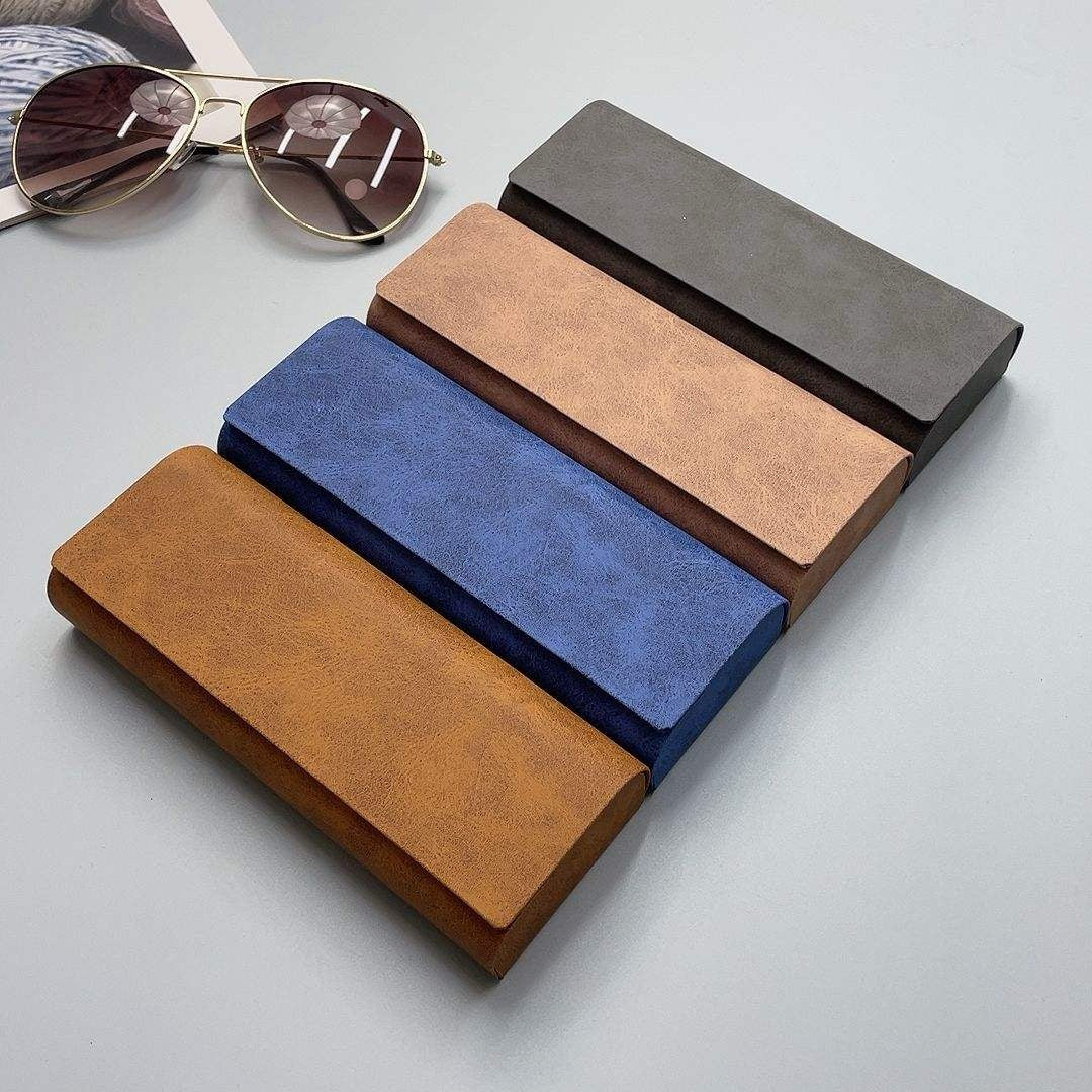 Set of four eyeglass cases in different colors on a light gray background