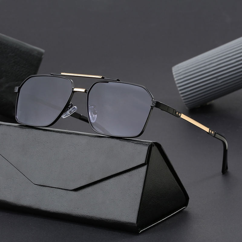 Sunglasses with gold frame and black lenses on a dark surface