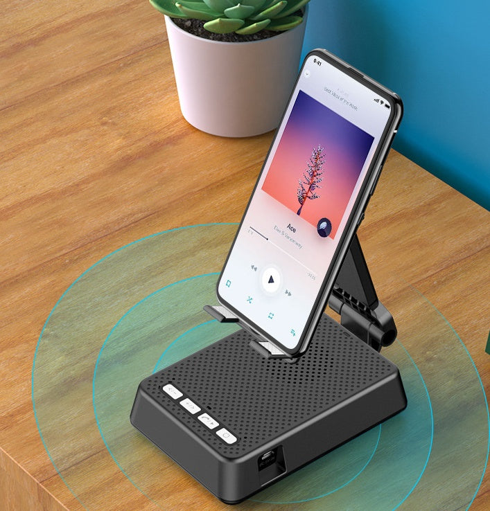 Phone dock with smartphone on a wooden surface with a plant in the background