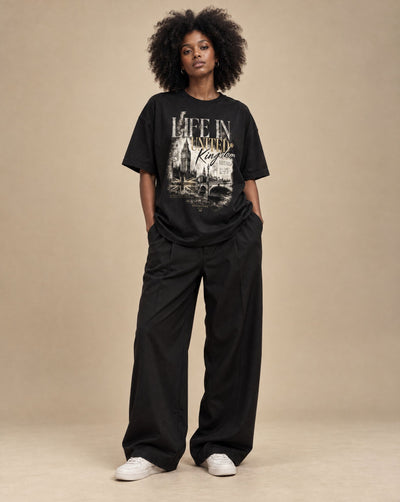 Female model wearing SHOPHOODIE LIFE IN UNITED KINGDOM Unisex Oversized T-Shirt — 300 GSM, studio shot