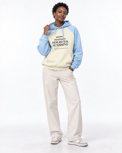 Female model wearing the SHOPHOODIE® Mindset Holiday & Sunshine Raglan Hoodie in Mild Apricot with Sky Blue – white studio