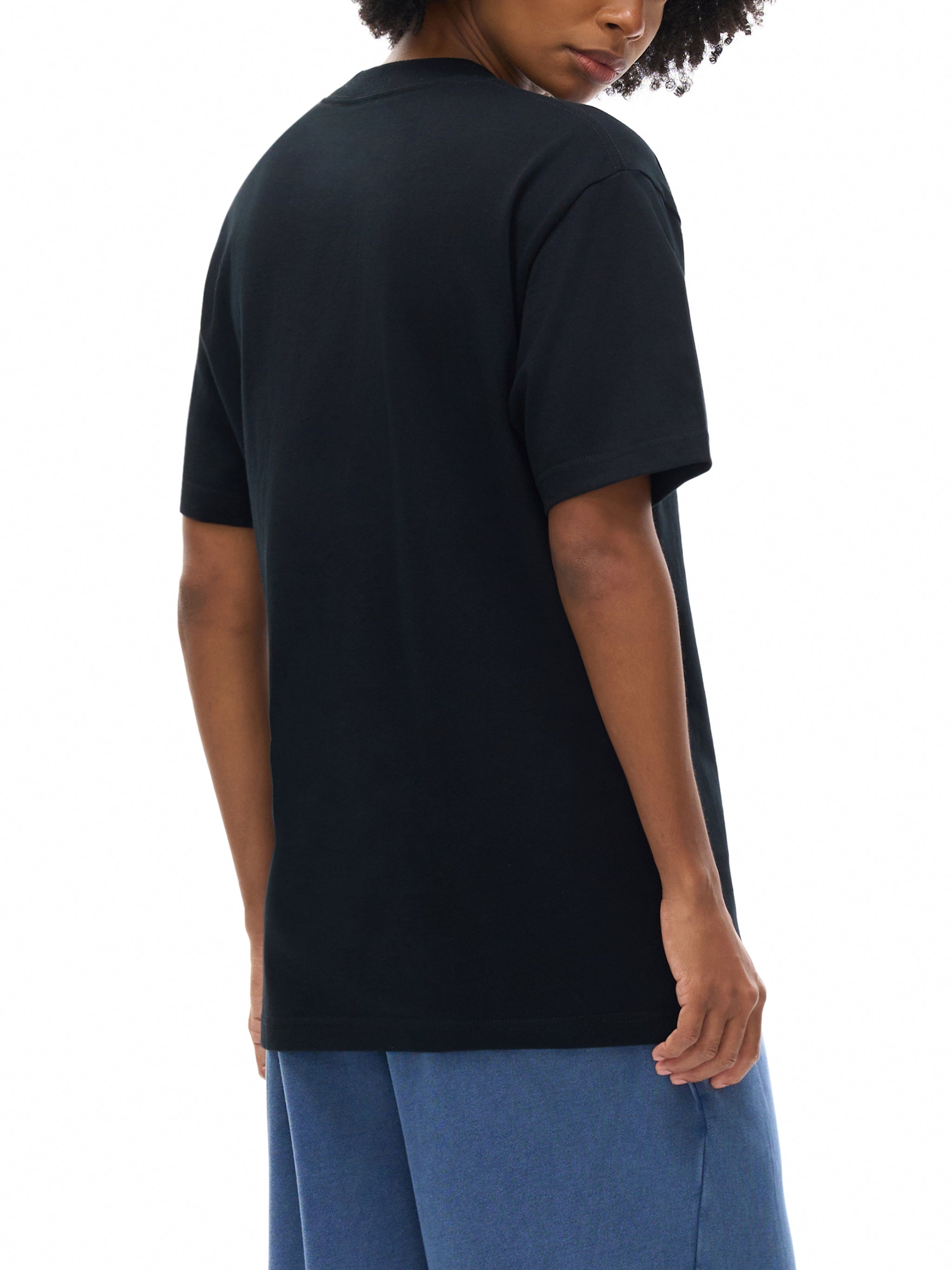 Person wearing a black t-shirt and blue pants on a white background